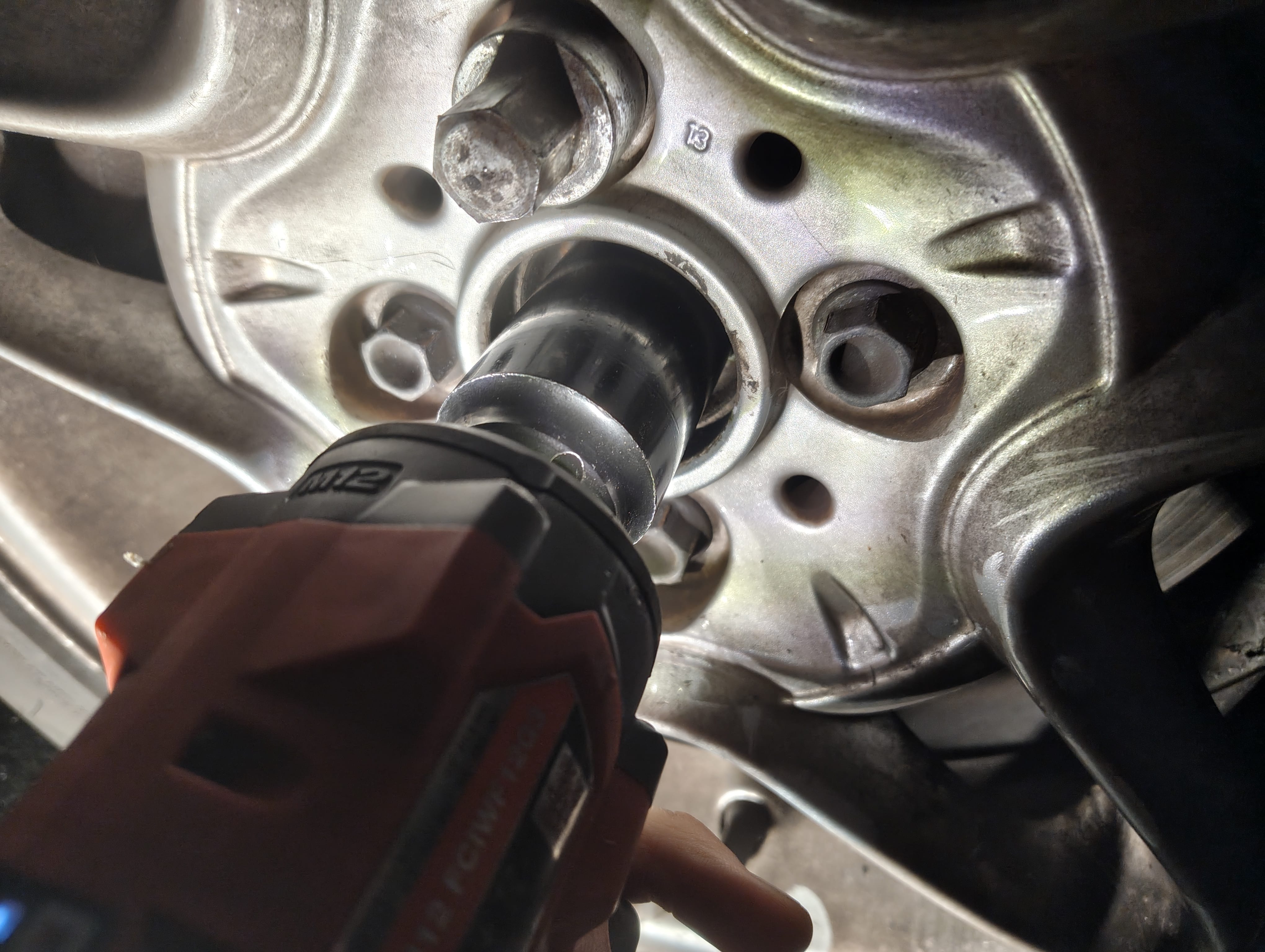 Loosening the front passenger-side driveshaft nut with an impact wrench